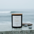 Marea Limpia soy candle with lid on in a crisp coastal scene with sea salt and ocean air atmosphere